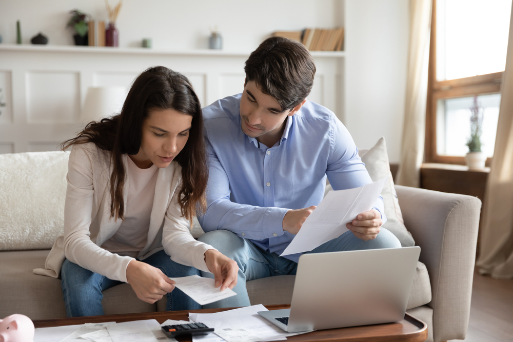 Couple reviewing expenses to save money