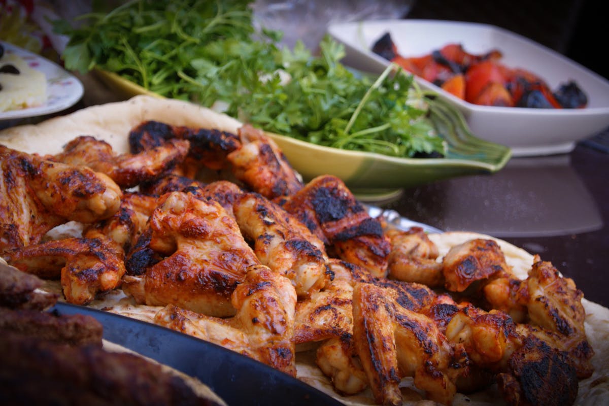 A bunch of BBQ chicken on a platter made by a private chef