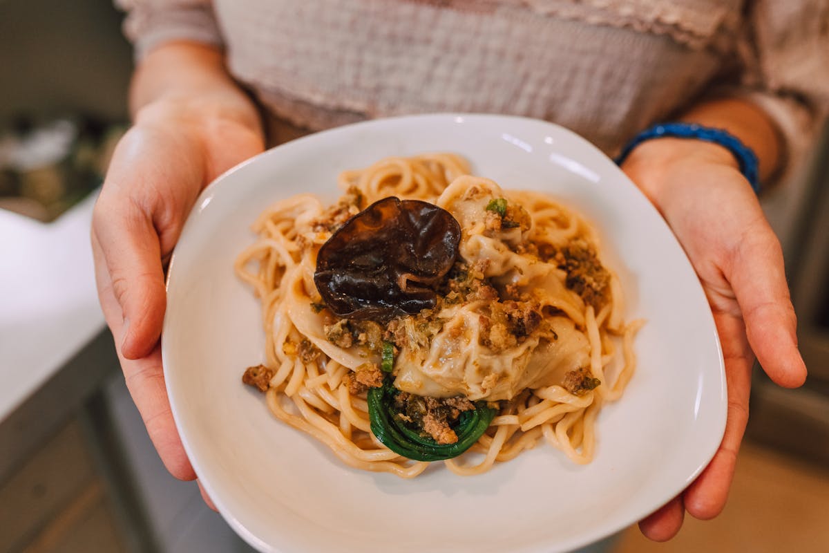 A private chef holding up a dish of food to the camera