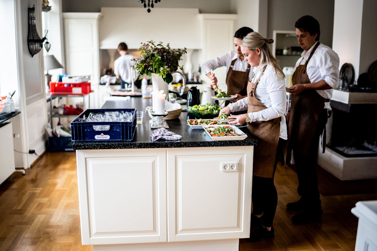 A bunch of chefs in a kitchen creating dishes for people