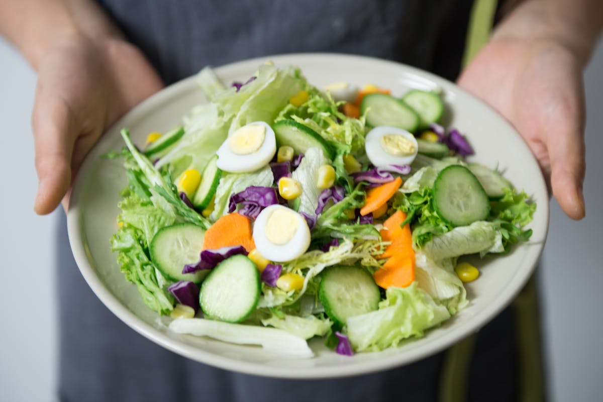 A private chef showing a salad to the camera