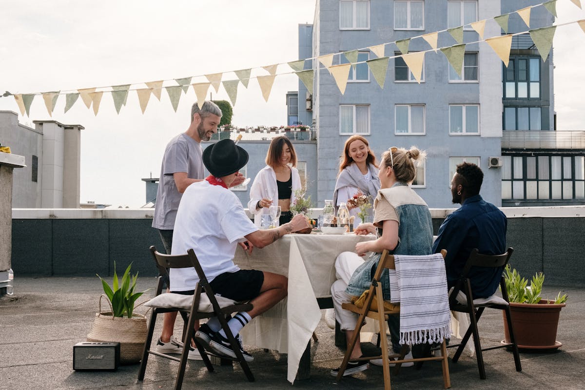 A bunch of people eating at a table on the roof of a building