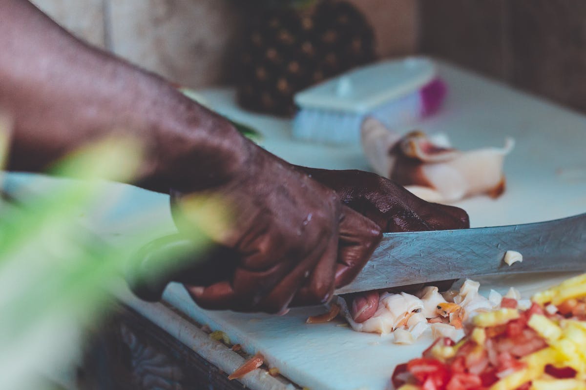 A chef cutting some fruit on a cutting board