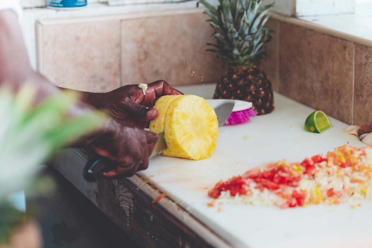 A chef cutting a bunch of fruit