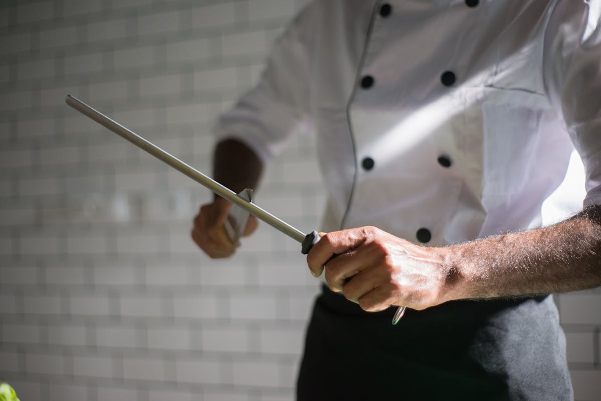 A chef sharpening a knife in a kitchen