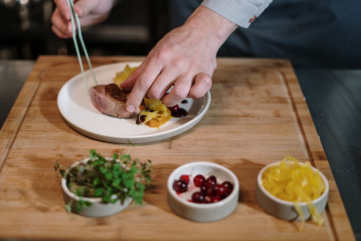 A private chef cutting up some food on a plate