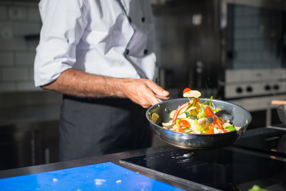 A private chef cooking up some veggies in a pan