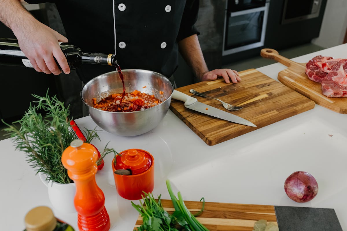 A private chef pouring some liquid into the bowl of food