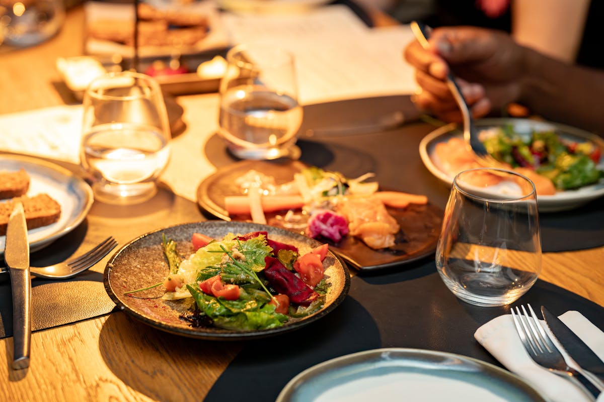 A bunch of people sitting at a table, eating some food made by a private chef