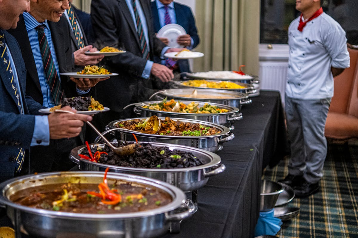 A bunch of men in suits getting food at a company event