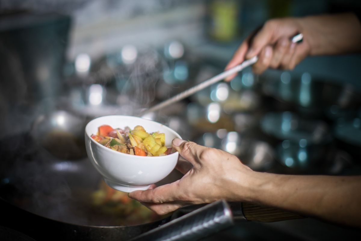 A private chef putting some food into a bowl