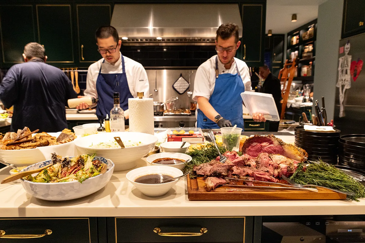 A bunch of personal chefs in a kitchen creating a meal