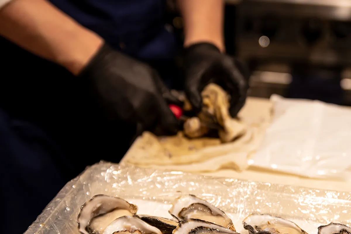 A personal chef cutting up some seafood for a client