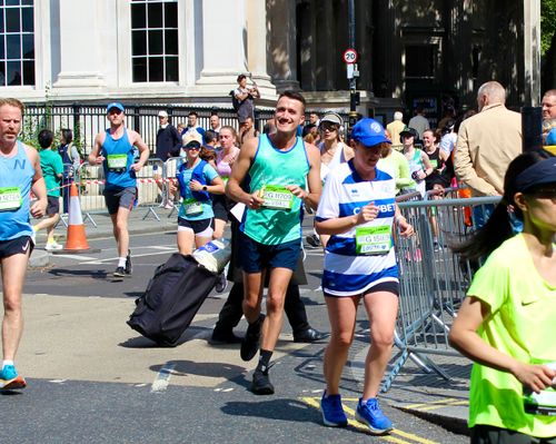Chris smiles for the camera. He is wearing his green hospice running vest.
