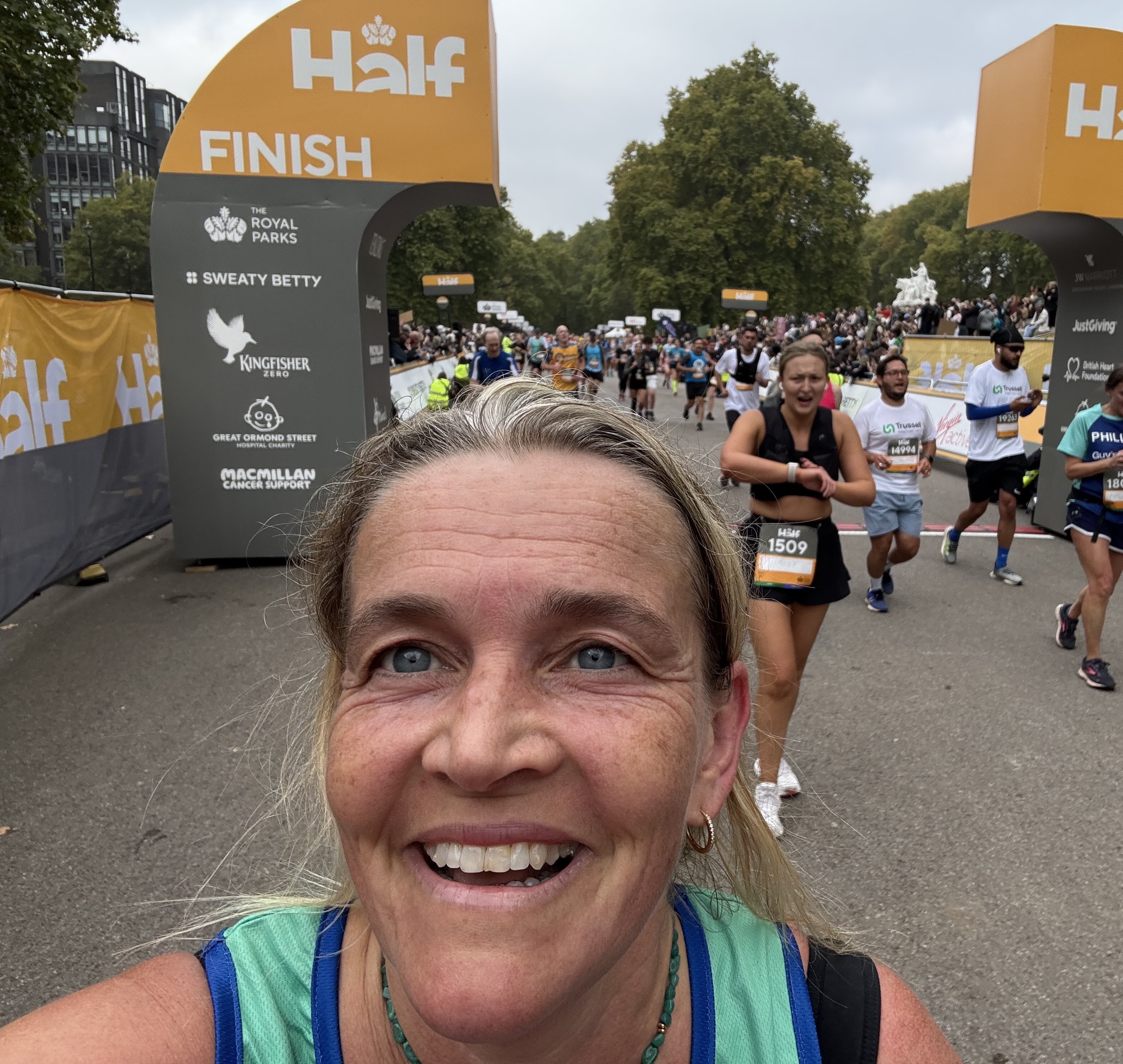 Runner, Sandra, smiles to the camera holding up her finishers medal.