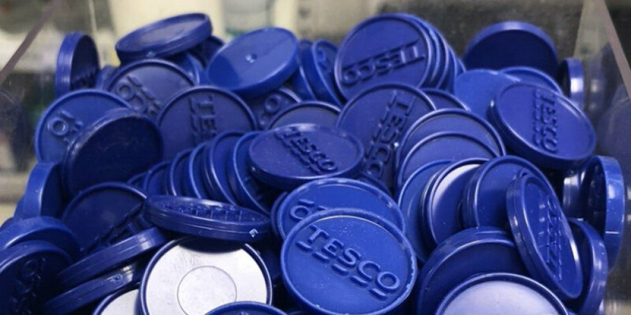 A mound of the plastic blue tokens which have the Tesco logo engraved in them.