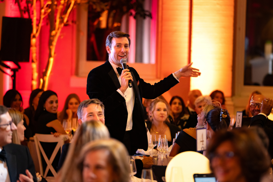 Auctioneer, Tom Best, walking around the room carrying out the live auction taking bids from guests.