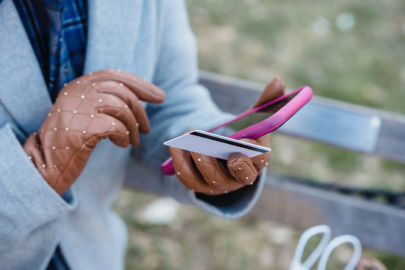 A photo of a woman holding a phone and a credit card in her hands