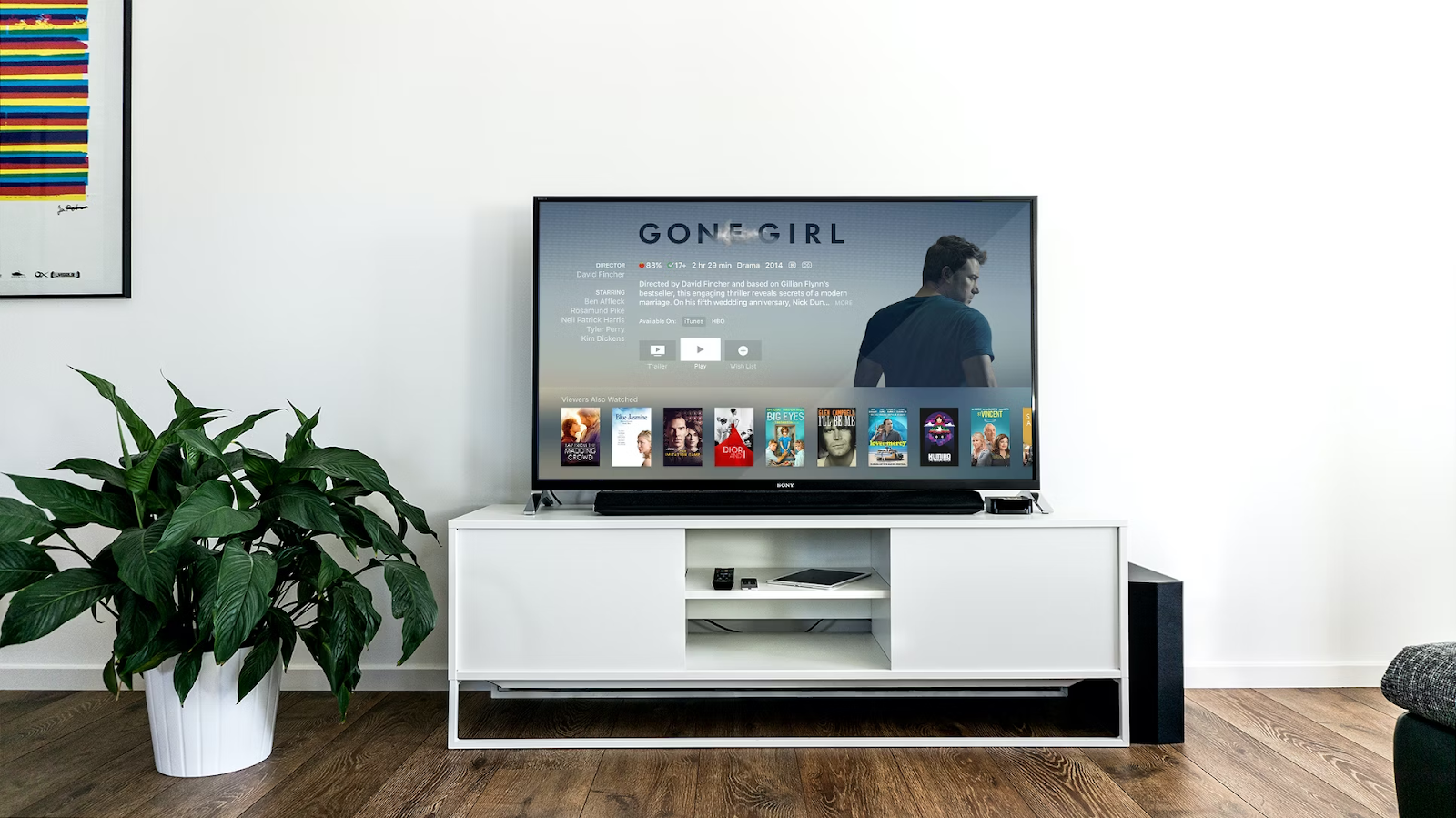 A photo of a TV placed on a table displaying a movie title