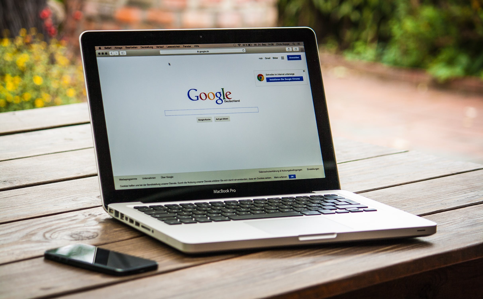 A close-up photo of a Macbook displaying the Google homepage