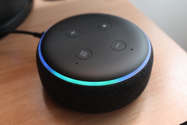 A photo of an Amazon Alexa Echo Dot 3 on a wooden surface