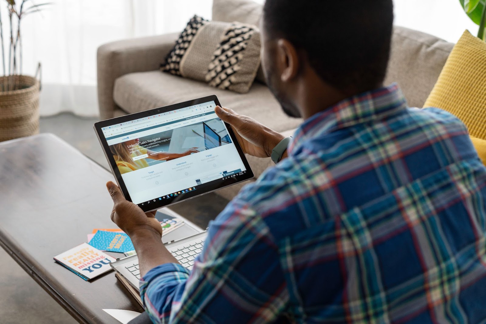 A back-shot photo of a person using LinkedIn Premium on a tablet