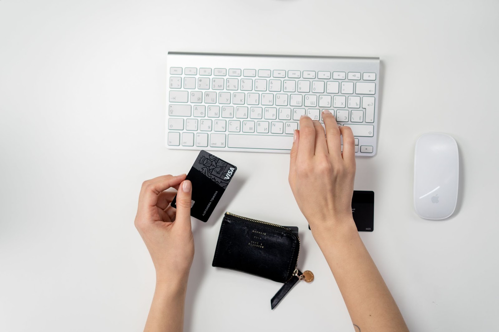 A photo of a person typing payment card numbers on a keyboard