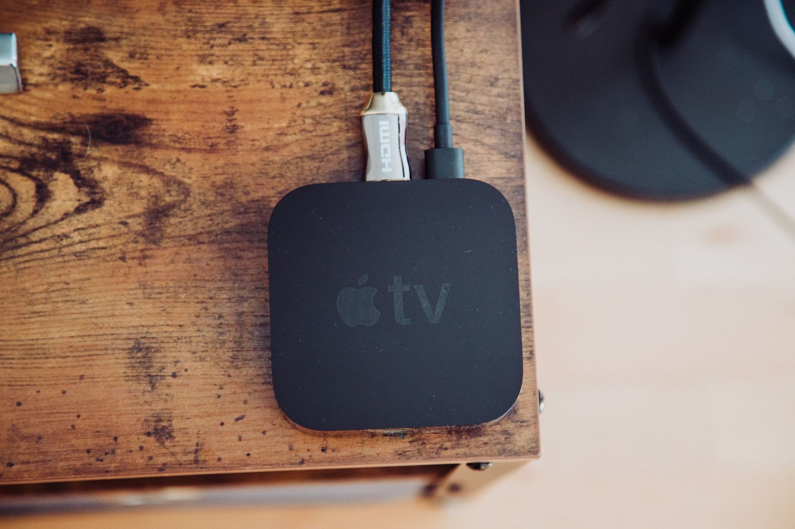 A photo of an Apple TV box on a wooden table