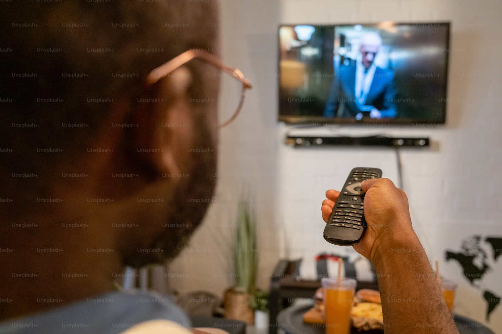 A photo of a person pointing a remote control at the TV