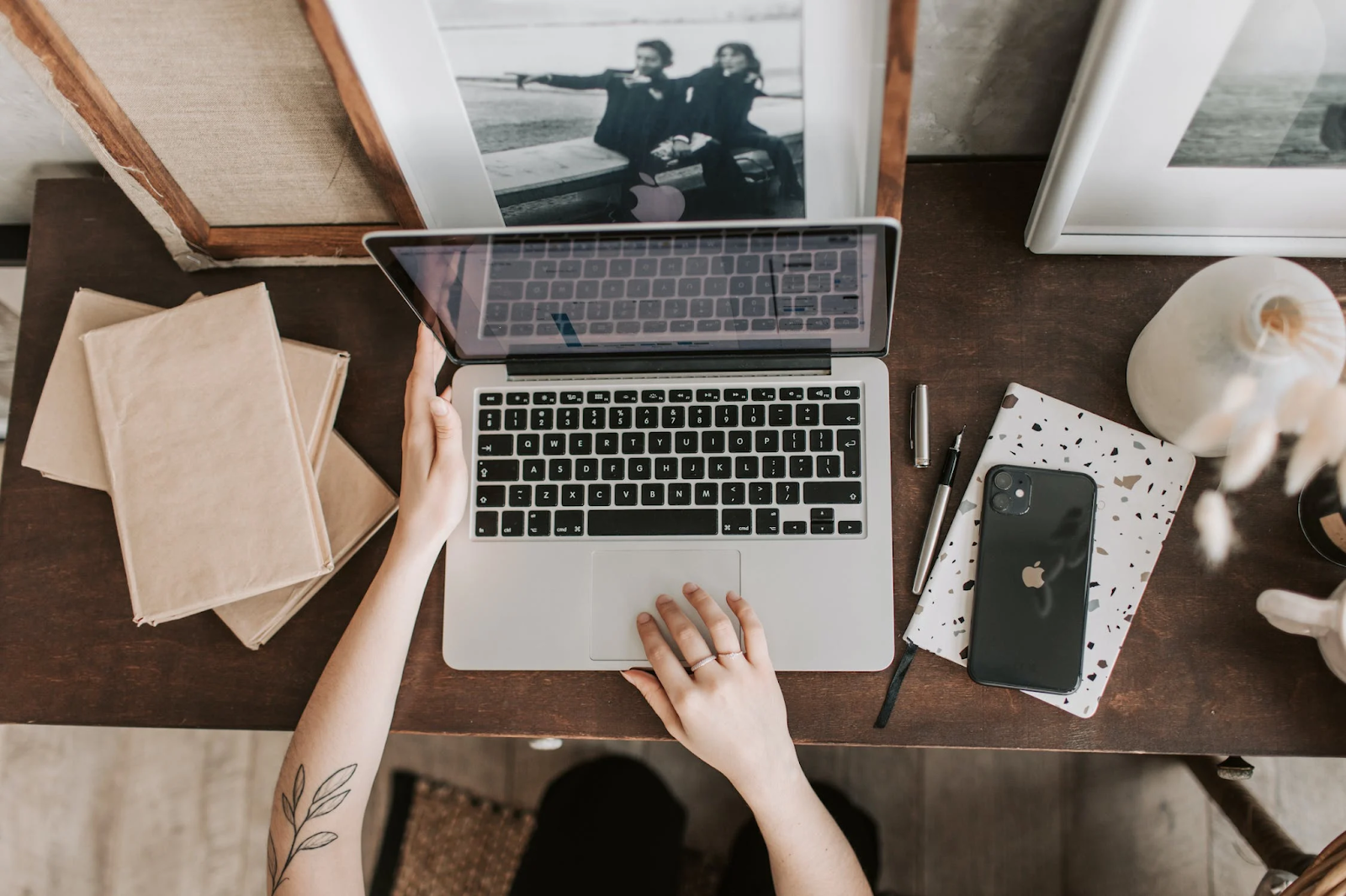 A bird’s eye photo of a woman using a laptop in a workspace