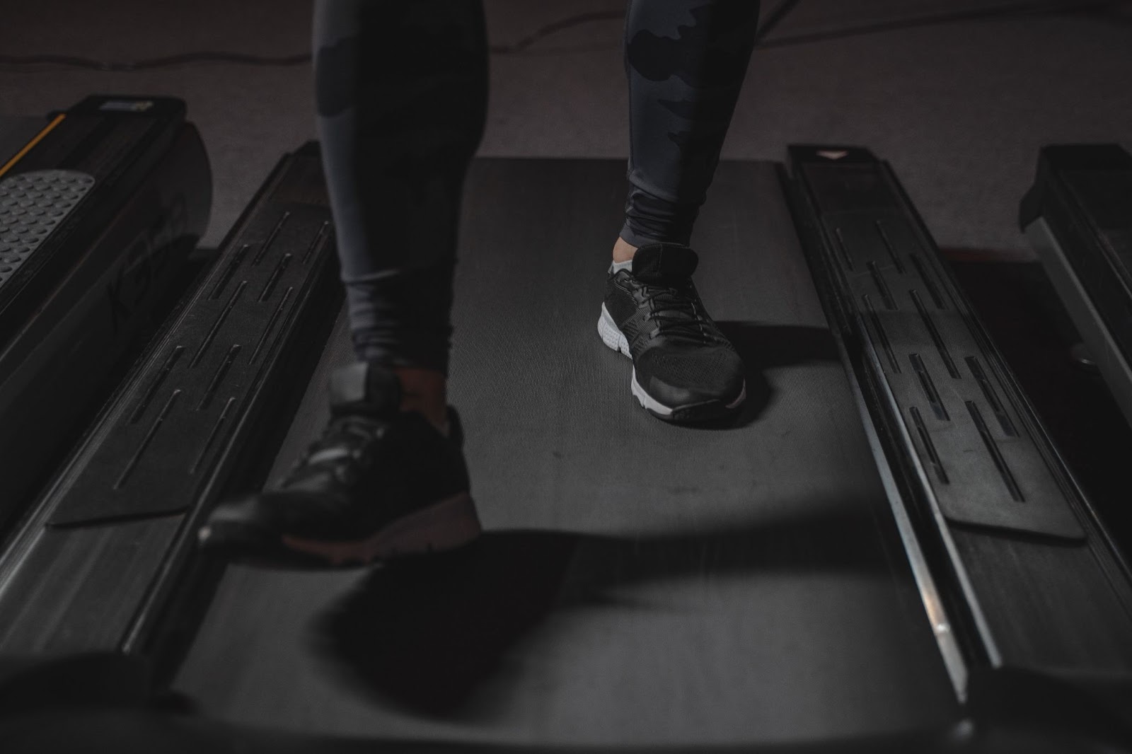 A close-up photo of a person’s feet while running on a treadmill