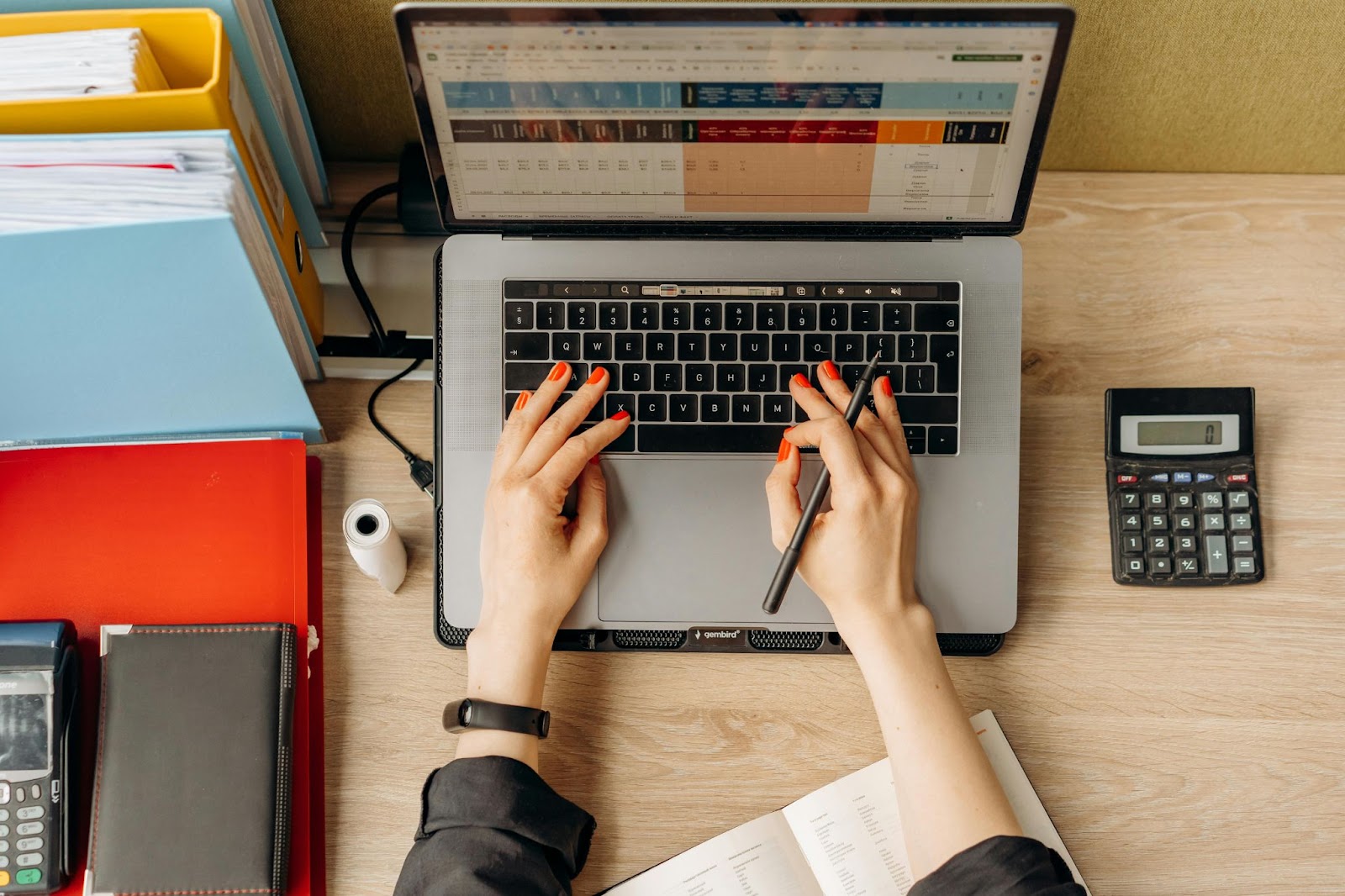 A bird’s eye view photo of a person doing financial calculations on a laptop