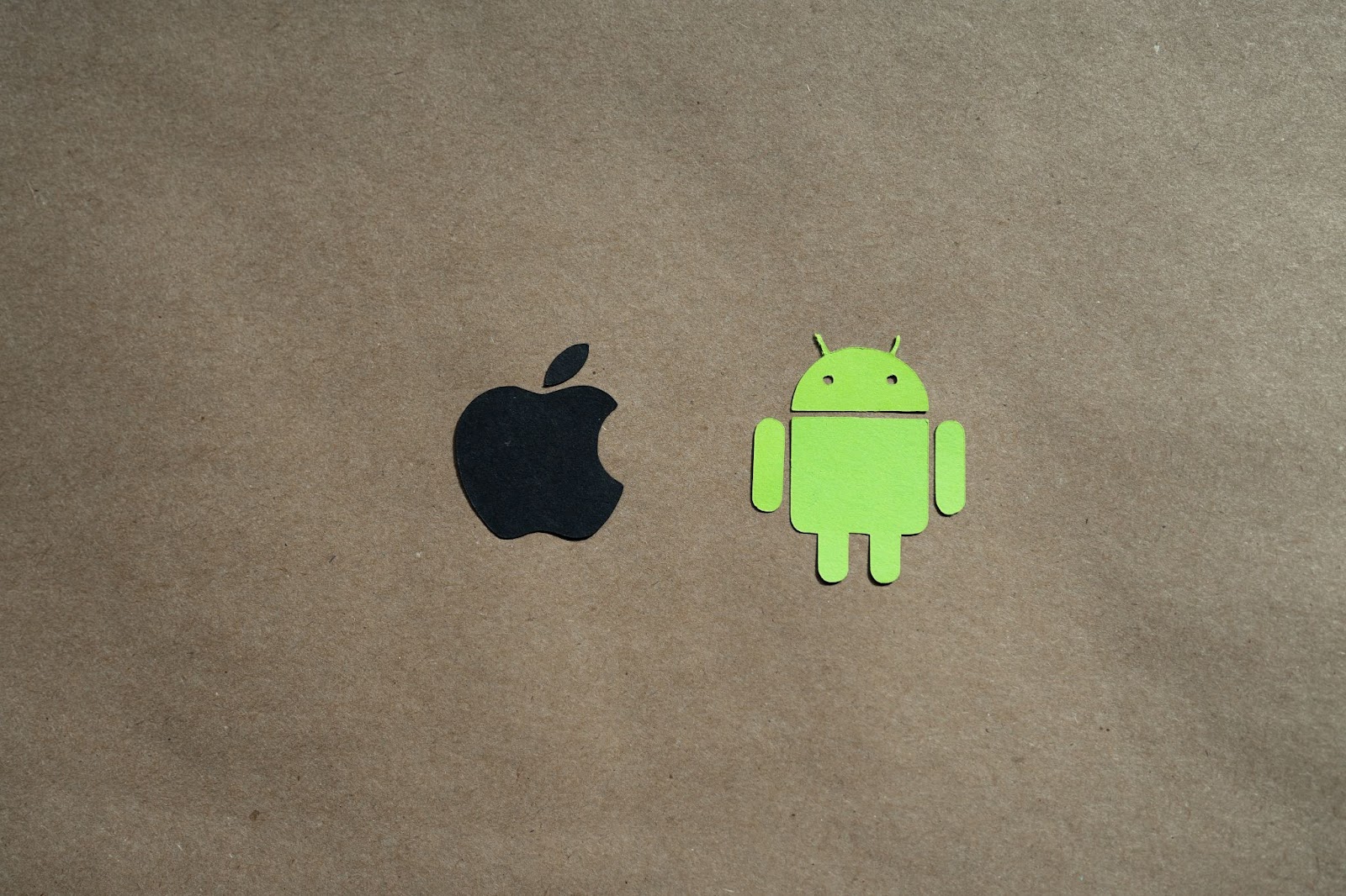 A photo featuring paper cut-outs of the Android and Apple logo