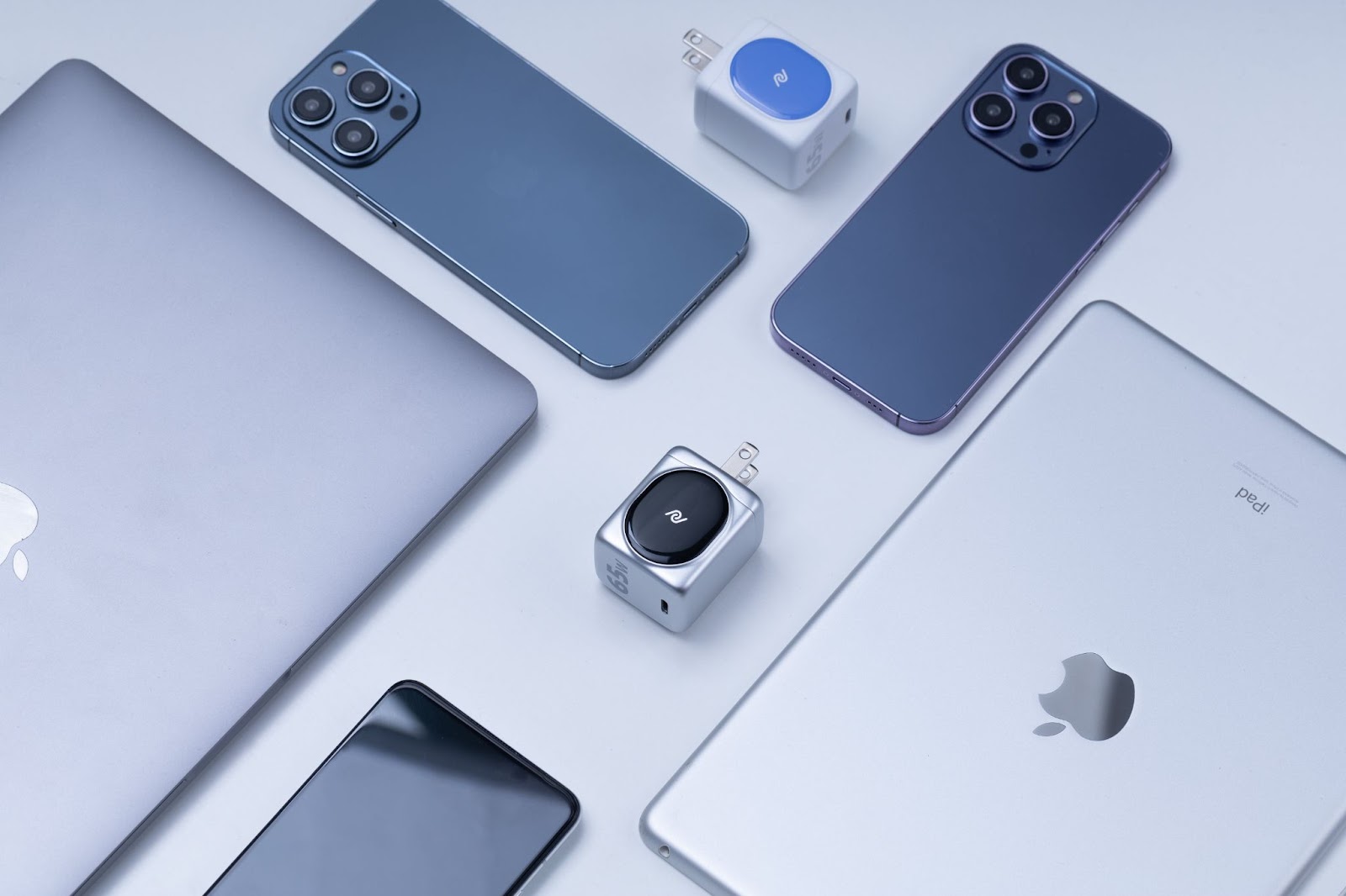 A photo of various Apple devices sitting on a white table