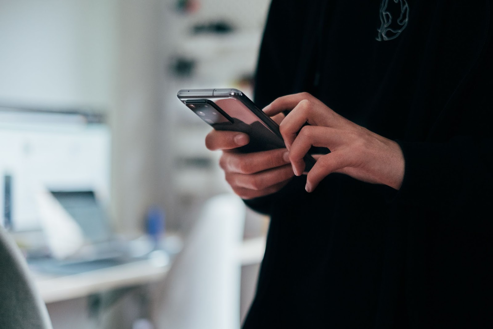 A photo of a person using a smartphone while standing up