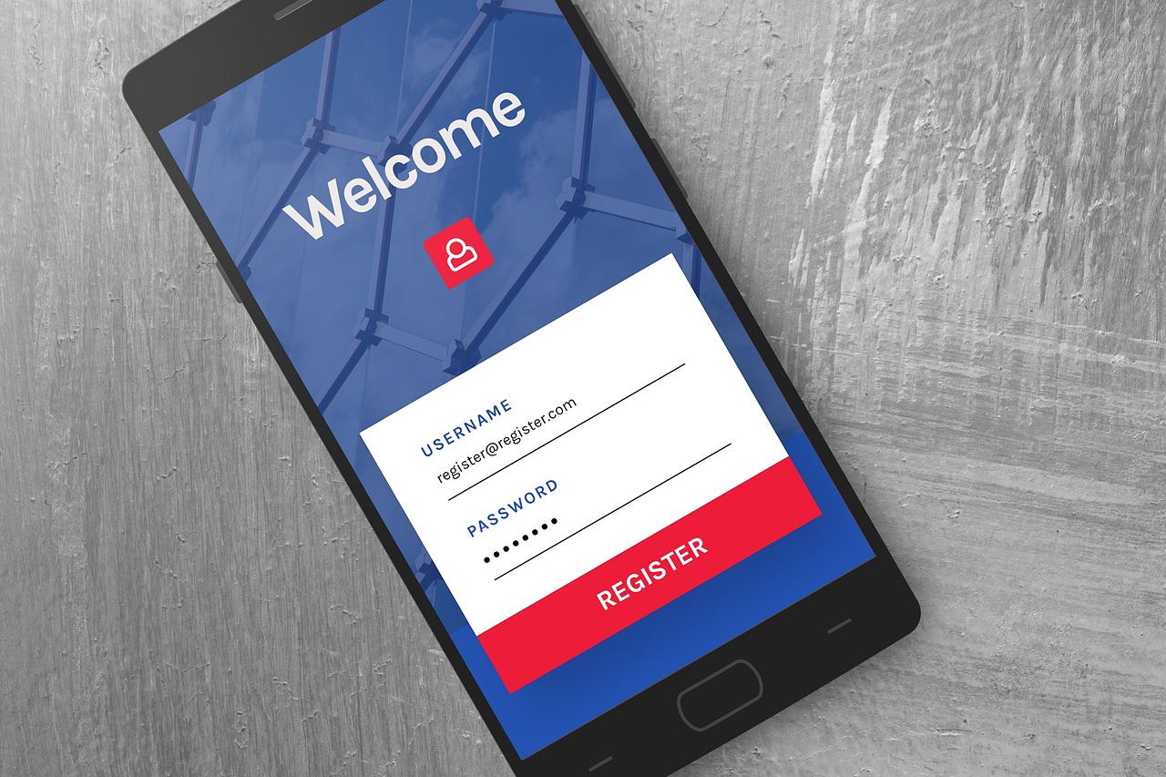 A photo of a smartphone on a gray surface, showing a registration interface, with masked username and password fields