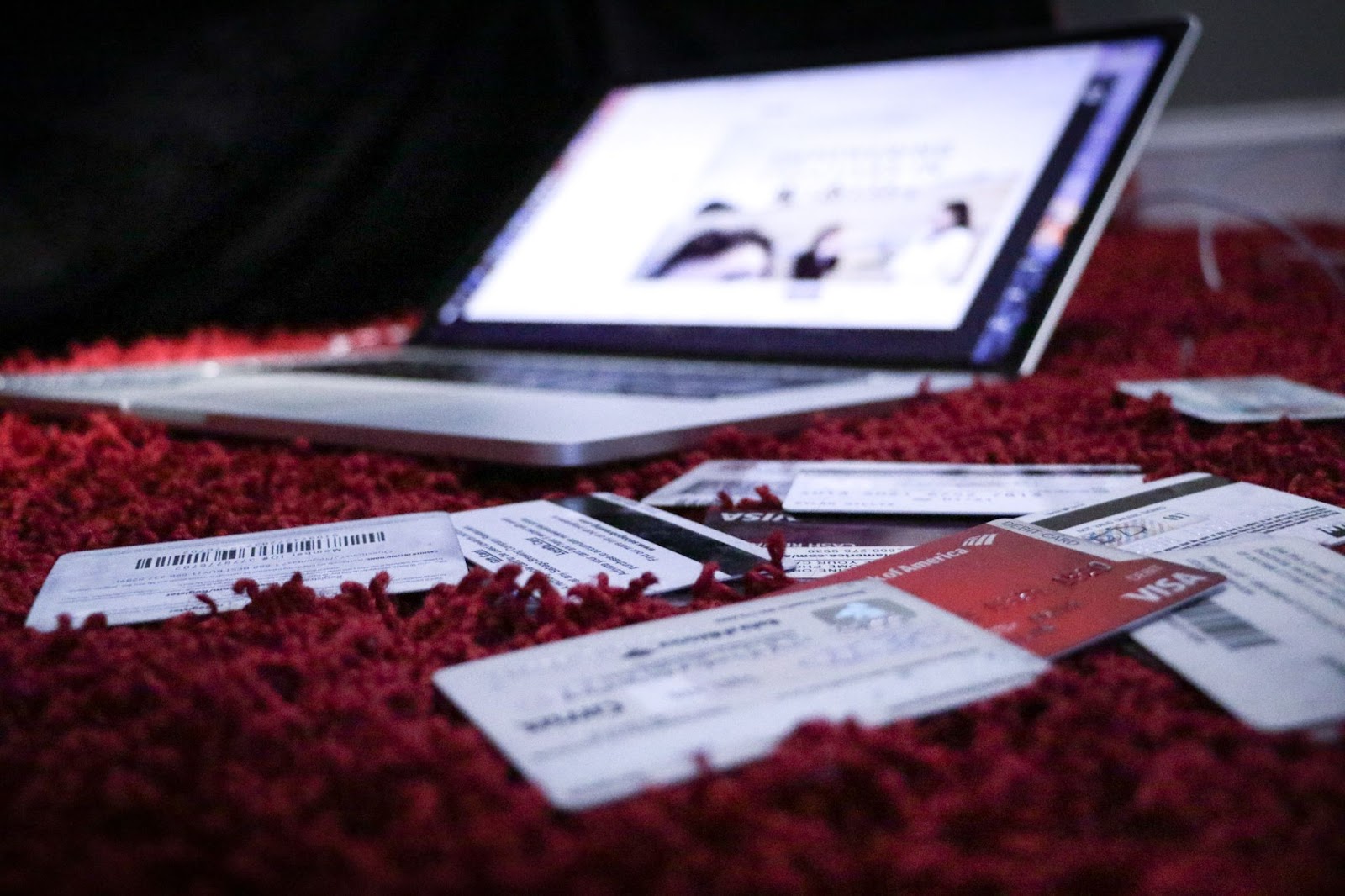 A photo of a laptop surrounded by payment cards