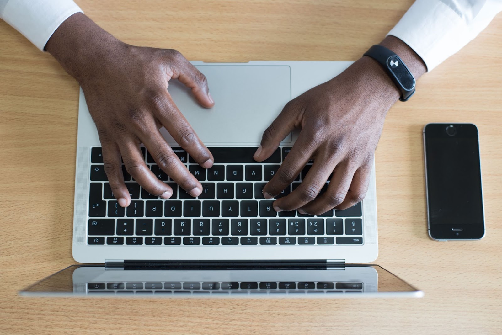 A bird’s eye view photo of a person typing on a laptop keyboard