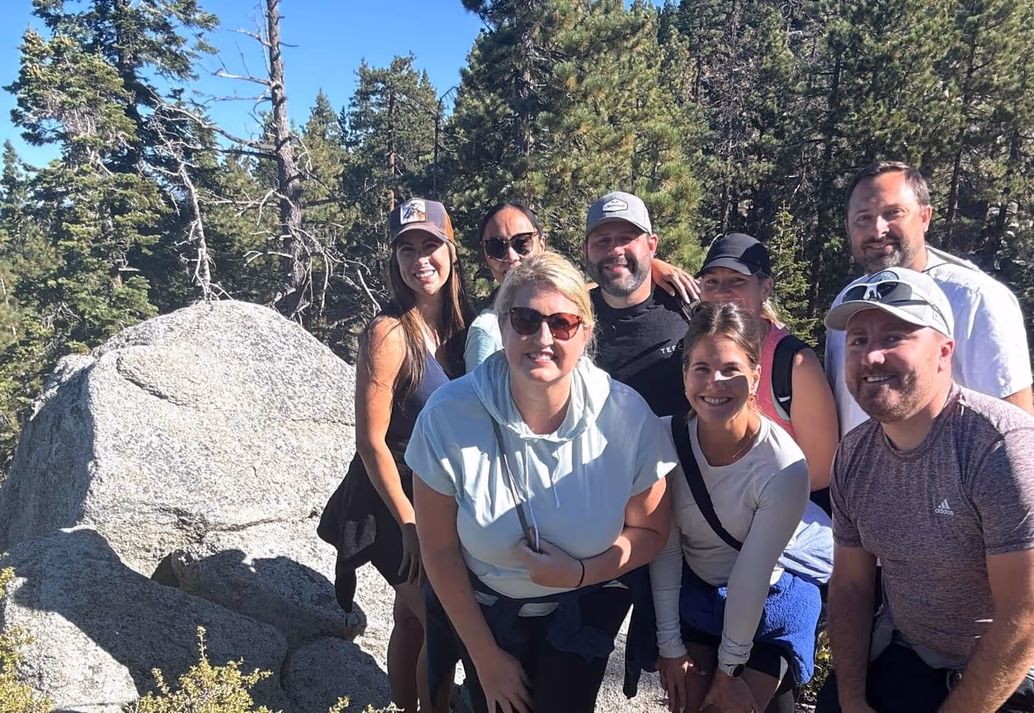A group of TEECOM employees smiling together for a photo on a hike.