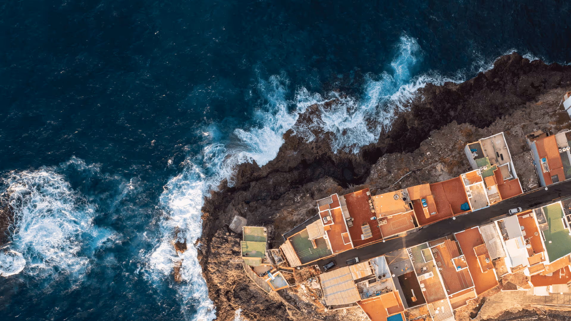 An aerial view of a building next to the ocean.