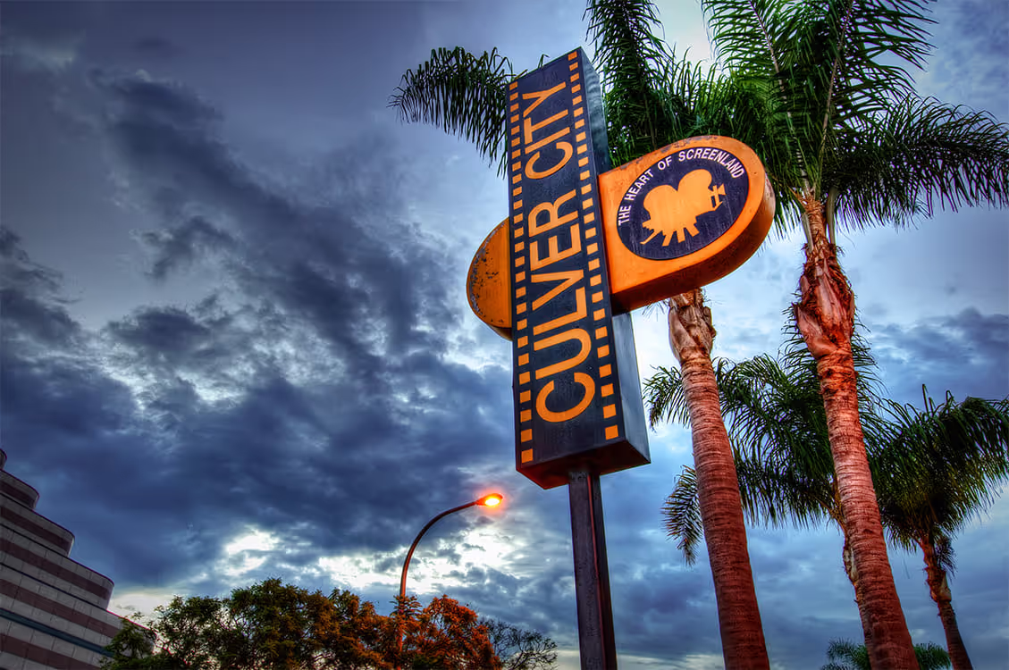 Culver City sign with palm trees against dramatic cloudy sky