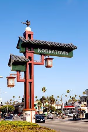 Koreatown landmark sign with traditional architectural elements against blue sky