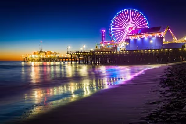 Colorful Ferris wheel illuminates Santa Monica Pier at twilight
