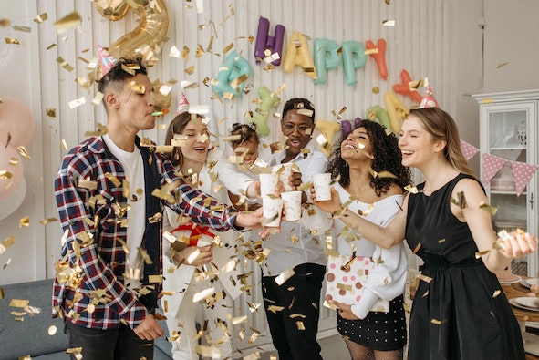 a group of friends is laughing at a birthday party