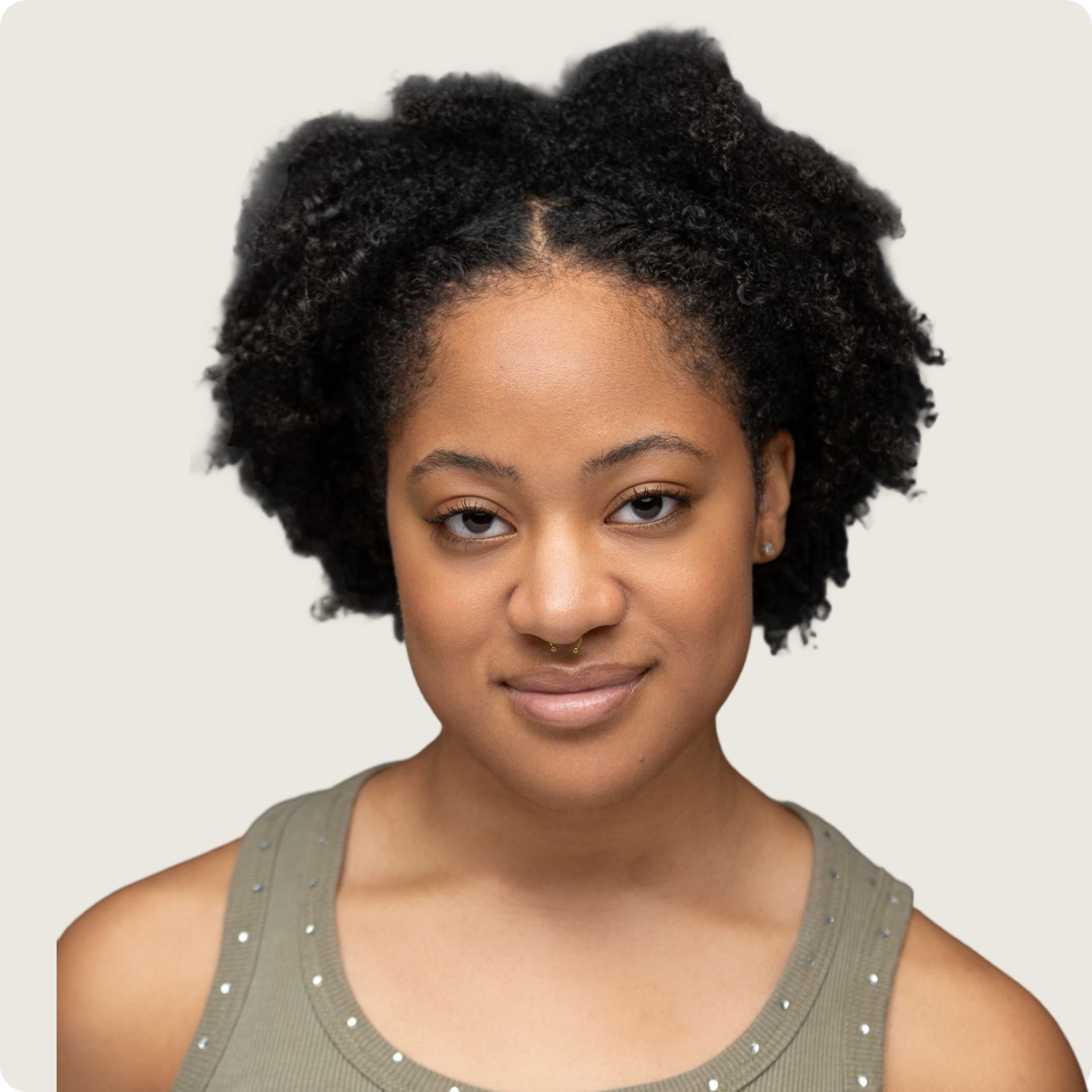 Portrait of a woman with natural curly hair, wearing a green tank top with small studs.