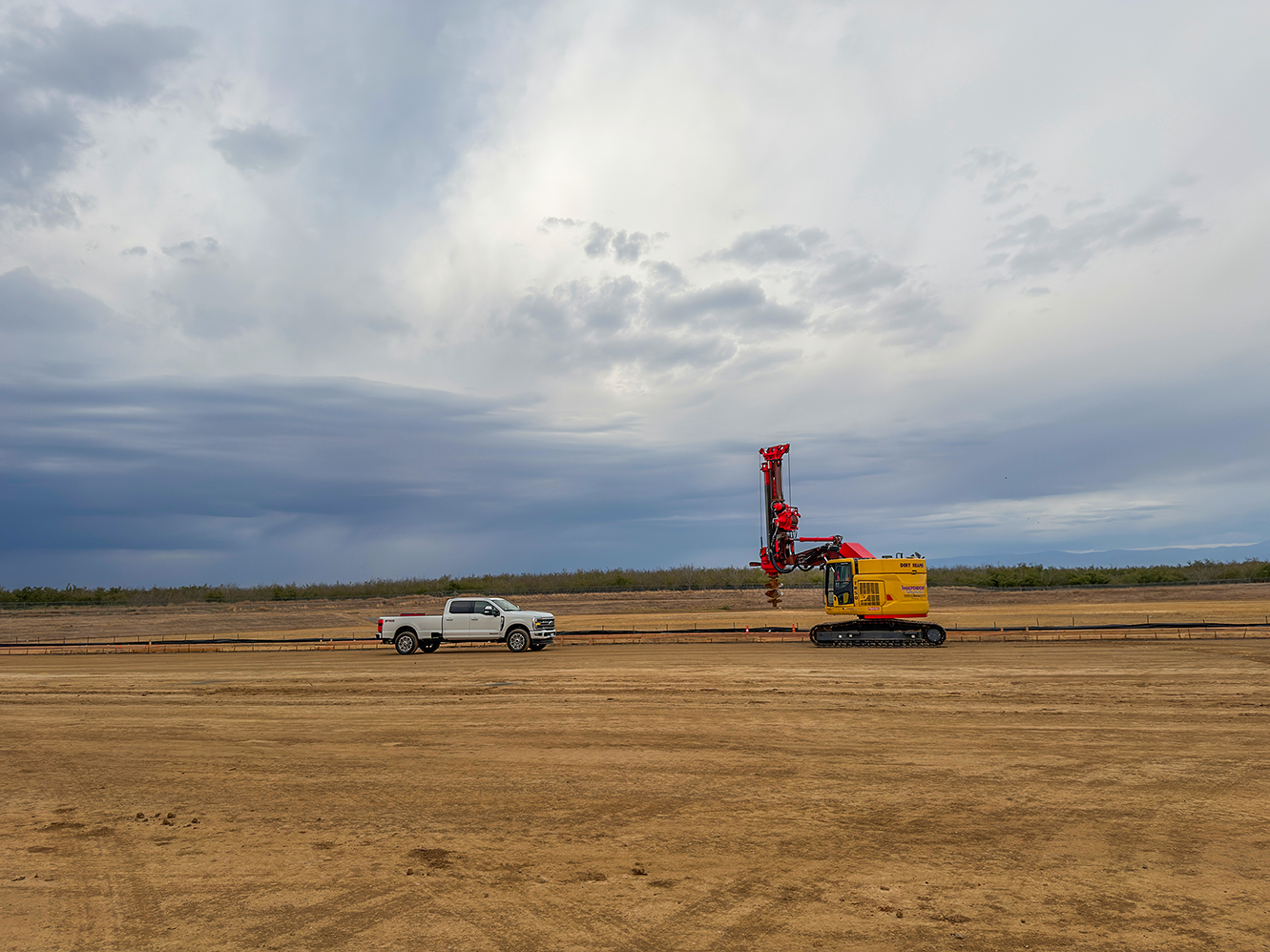 Heavy drilling equipment performing light-pole foundation work across the Walmart DC 6026 site in Red Bluff.