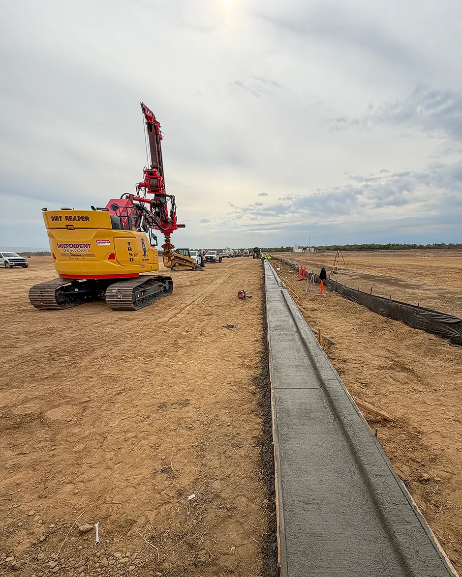 Drill rig and site preparation for deep parking-lot light-pole foundations at the Red Bluff Distribution Center.