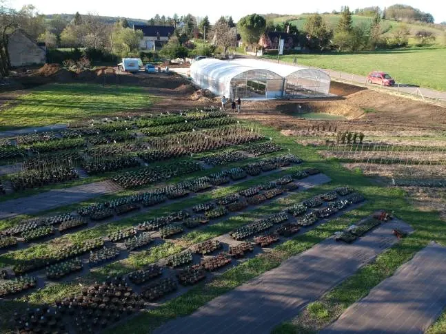 Vue du Jardin de Bohème, deux serres et des espaces extérieurs pour les plants