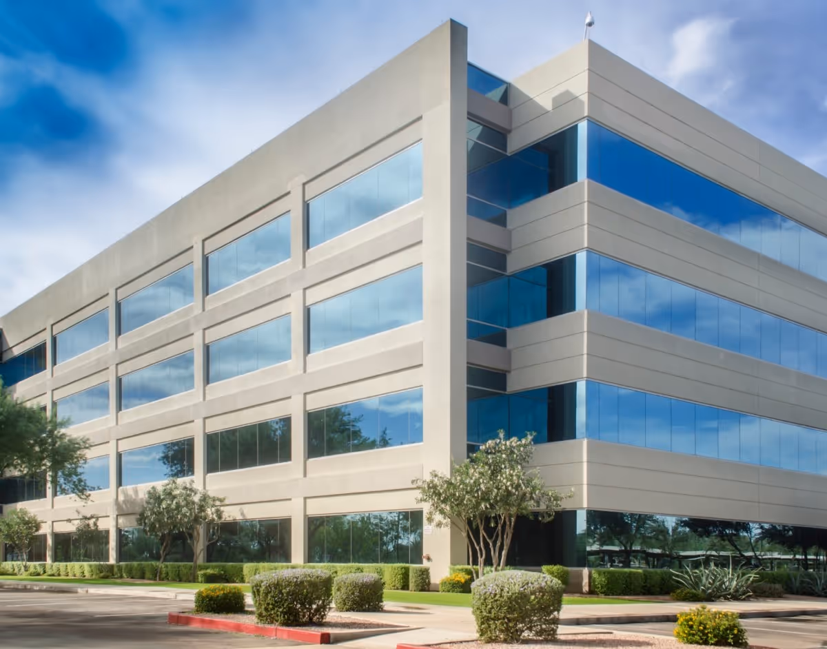 Modern glass and white office building with landscaped exterior