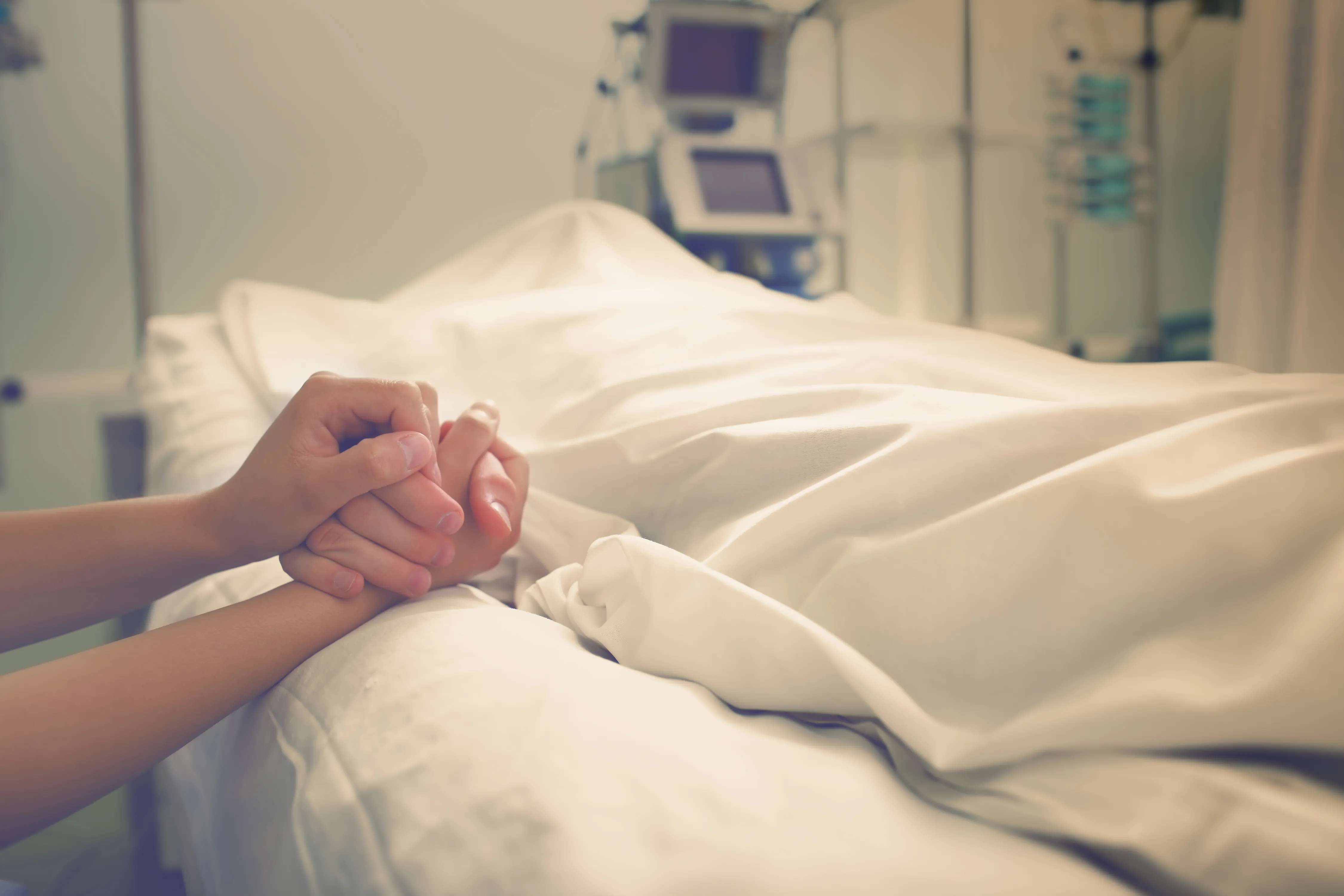 Holding the hand of someone on their deathbed
